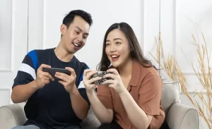 a-man-and-woman-sitting-on-a-couch-looking-at-a-cell-phone game