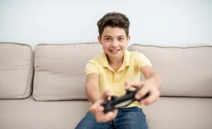 A smart child playing the games at sofa with remote